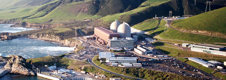Aerial view of Diablo Canyon Power Plant. The plant is on the coastline and consists of two domes next to a rectangular building.
