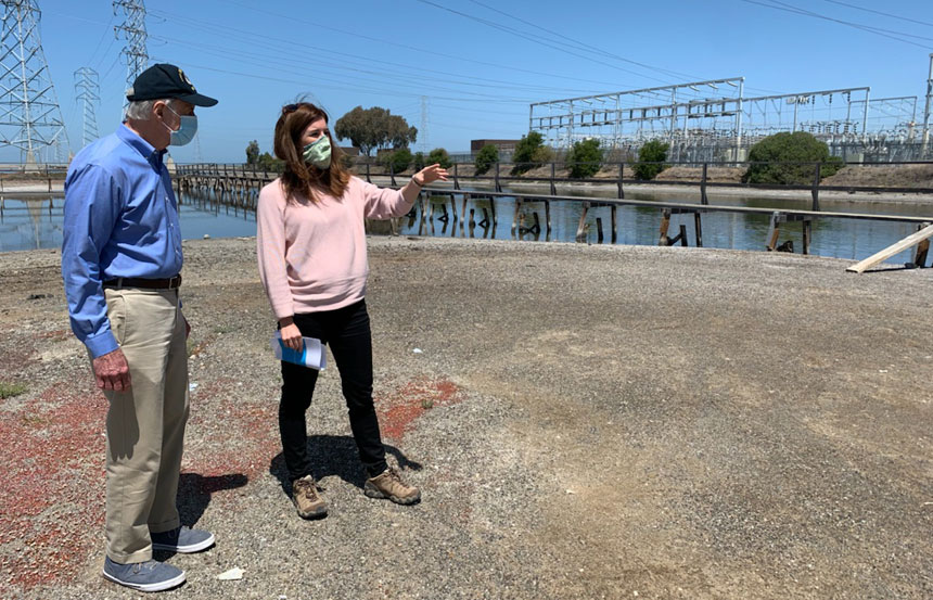 Two people talking in front of a levee
