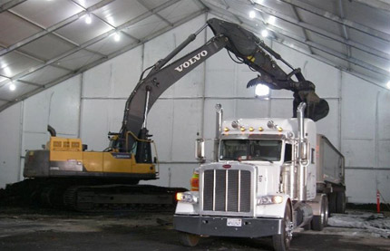 An excavator loading materials into a truck at a remediation site