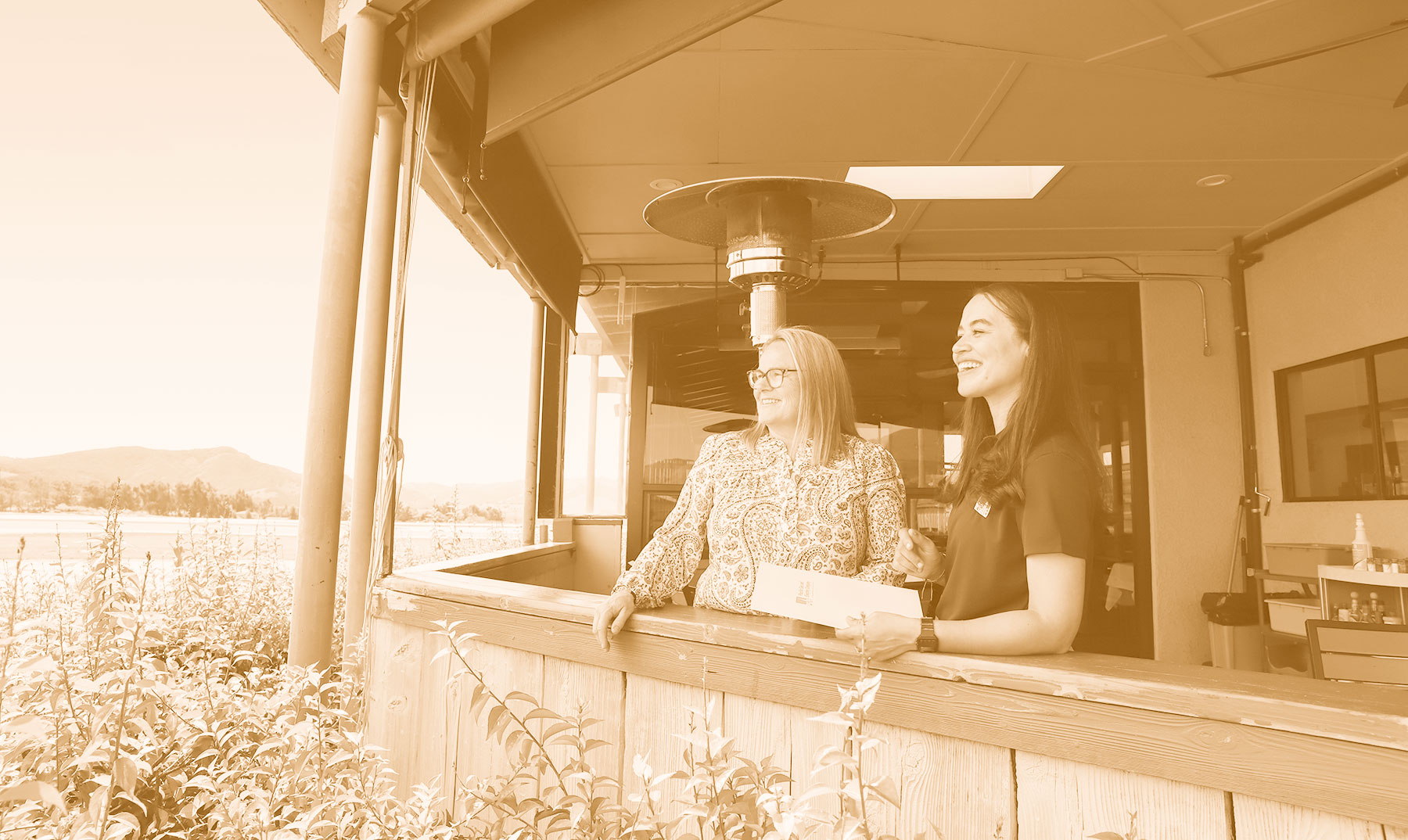 PG&amp;E employee and customer standing on a porch looking out at a field